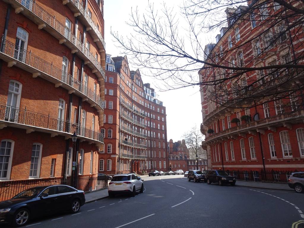Street of red brick mansion blocks in London under a clear sky
