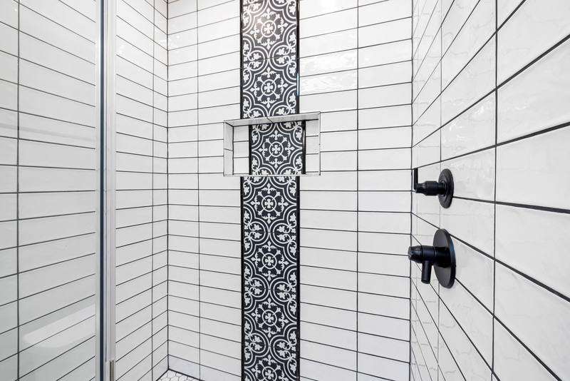 Refitted shower with patterned tiles and black fittings